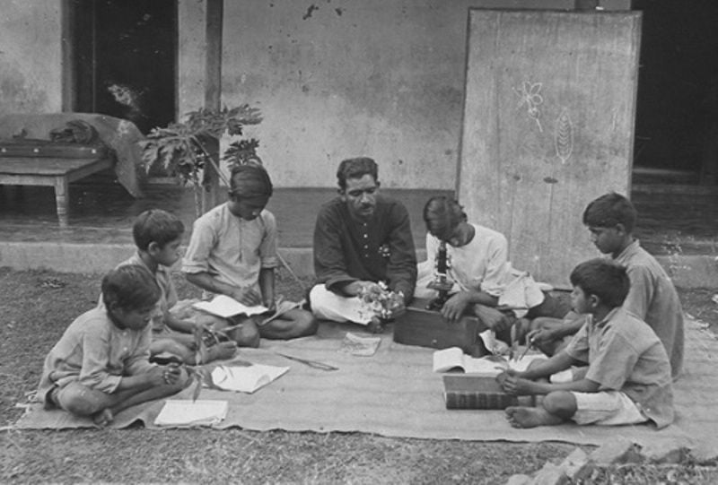 A boy studying the microscope at the Sri Niketan school