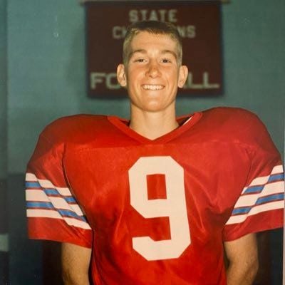 A childhood photo of Marty Smith in a football jersey