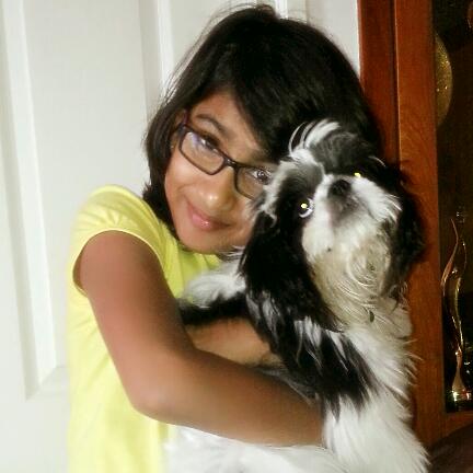 A childhood photo of Riya Shibu with her pet dog Oreo