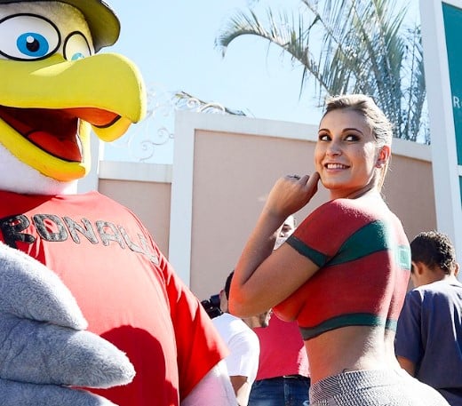 A fan wears a bird costume with the name of Cristiano Ronaldo on the chest poses with Andressa Urach, who painted her upper body with Portugal