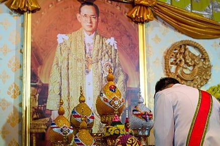 A government officer while paying tribute to the portrait of King Bhumibol