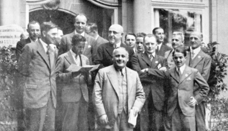 A group picture of the Chess Masters in the 1932 Bern tournament in which Sultan Khan appears to be reading a document
