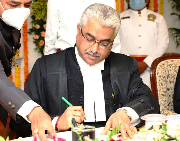 A photo of Aravind Kumar taken while he was signing the documents after assuming the post of Chief Justice of the Gujarat High Court