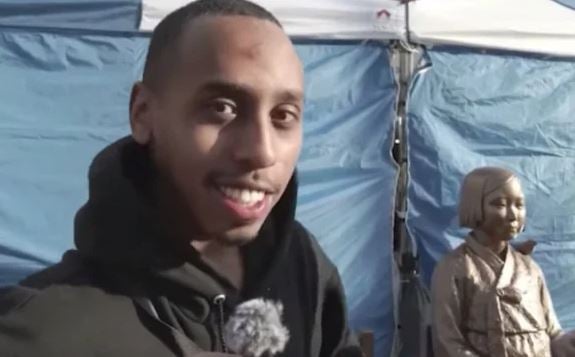 A photo of Johnny Somali taken before the statue in South Korea