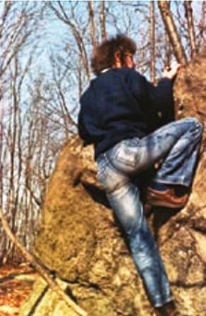 A photo of Kosterlitz taken while he was climbing a large boulder at the university