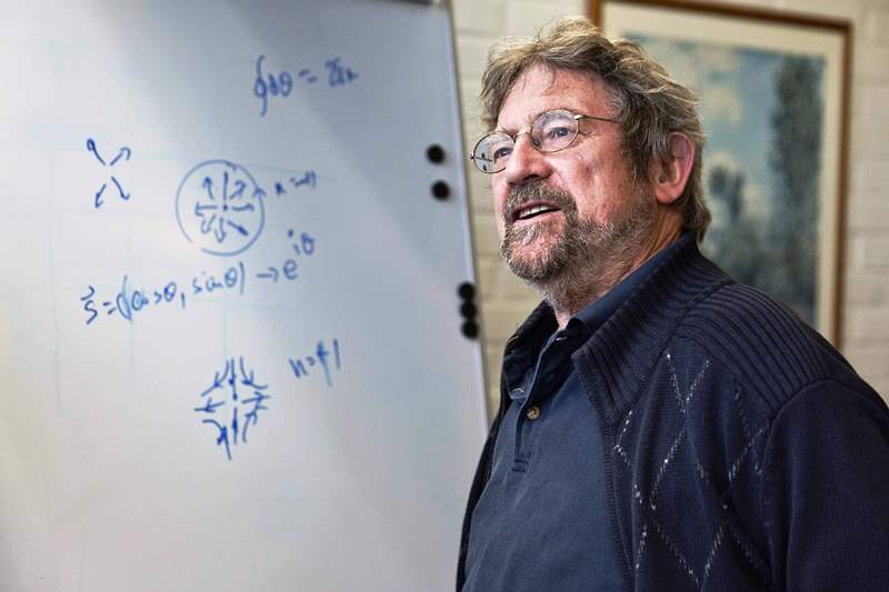 A photo of Michael Kosterlitz taken while he was solving a physics equation on a white board