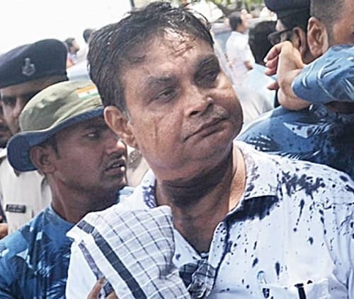 A picture of Brajesh Thakur after black ink was thrown on his face by a woman