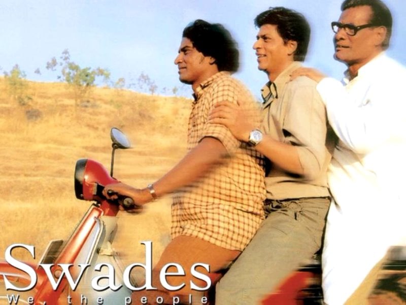 A picture of Daya Shankar Pandey, Shah Rukh Khan, and Rajesh Vivek riding a moped during a scene in the film Swades (2004)