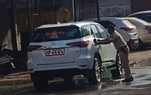 A policeman washing Sanjay Gaikwad