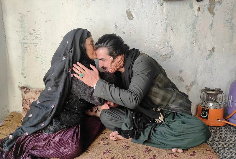 A poor lady embracing Ajmal Haqiqi and thanking him for his help