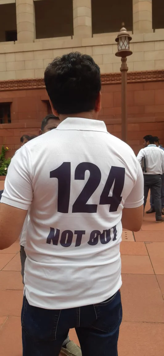 A protestor wearing t-shirt with 124 not out