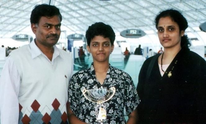 A young Harika Dronavalli holding a trophy