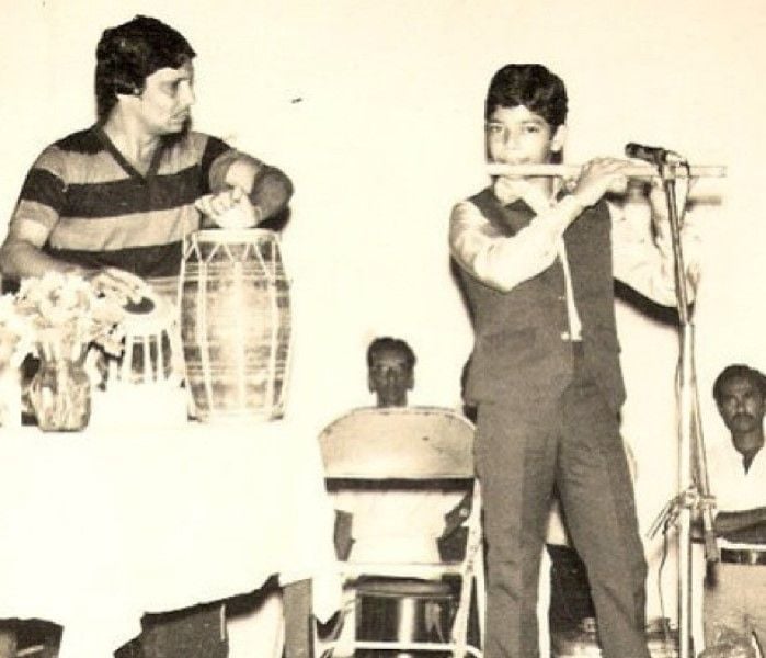 A young age photo of Rakesh Chaurasia playing a flute