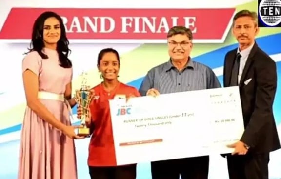 Aditya Yadav after winning while receiving an honour from P V Sindhu