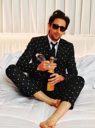 Adrien Brody holding a bottle of alcohol