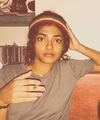 Ahilya Bamroo holding a cigarette