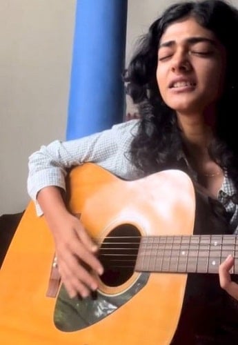 Ahilya Bamroo playing a guitar