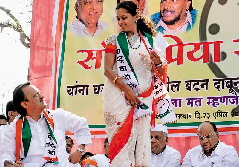 Ajit Pawar (extreme left), Supriya Sule (standing) and Sharad Pawar (extreme right)