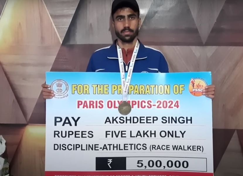 Akshdeep Singh holding Rs 500000 voucher given by government