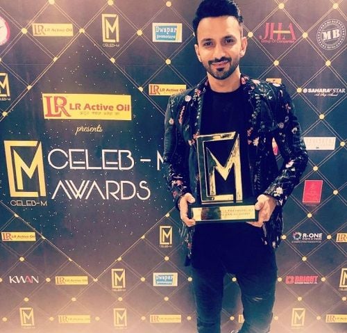 Ali Merchant holding his award