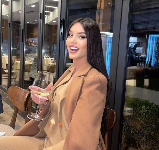 Amber Candy drinking white wine at a restaurant