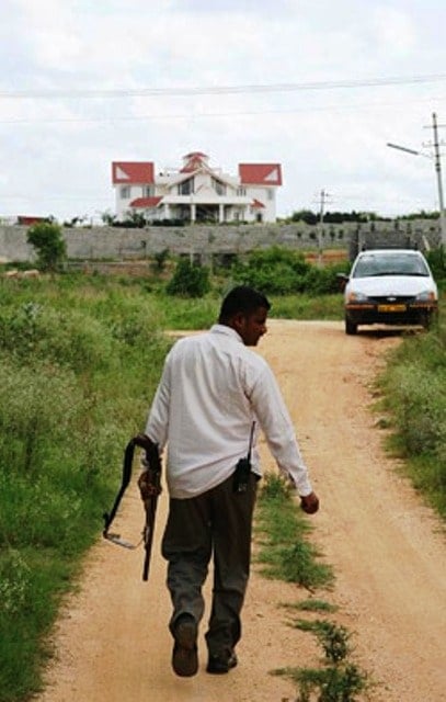An armed guard patrolling the perimeter of Muthappa Rai