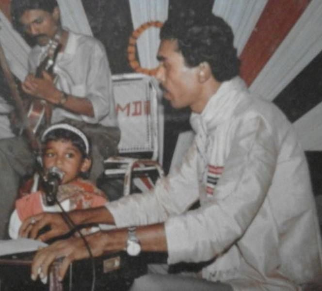 A childhood photo of Antara Mitra practicing singing with her father