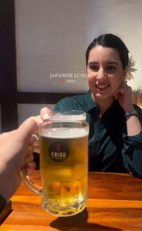 Anahita Dhondy holding a glass of beer