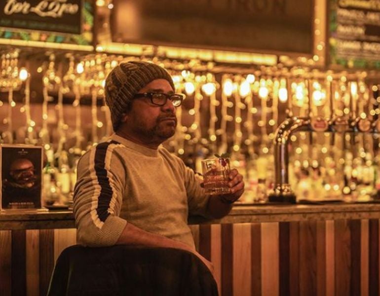 Aneez Bazmee holding a glass of whiskey