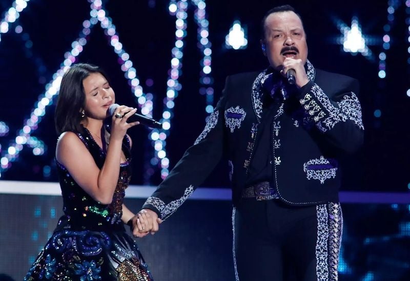 Ángela Aguilar and her father in a still from their performance at the 2018 Premios Tu Mundo at the American Airlines Arena in Miami, Florida