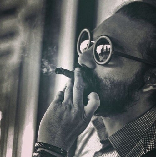 Aniket Chouhan smoking a cigar