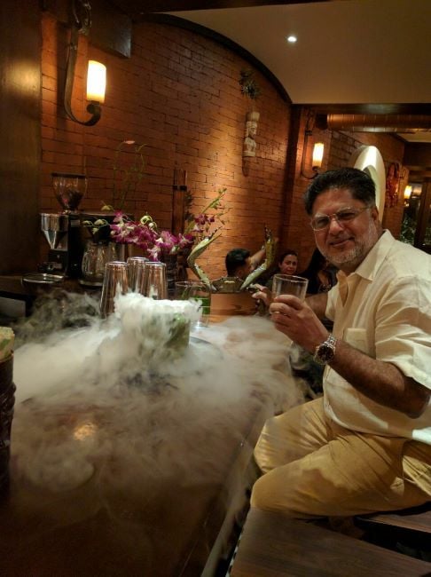 Anil Arora holding a glass of alcohol