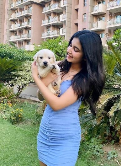 Anvesha Vij posing with a puppy
