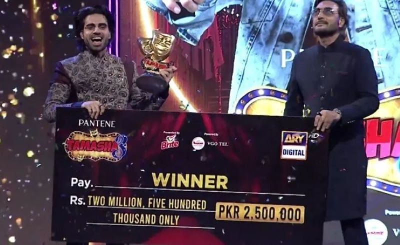 Aqeel holding the cheque after winning the show