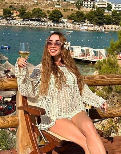 Arjeta Palushaj holding a glass of wine