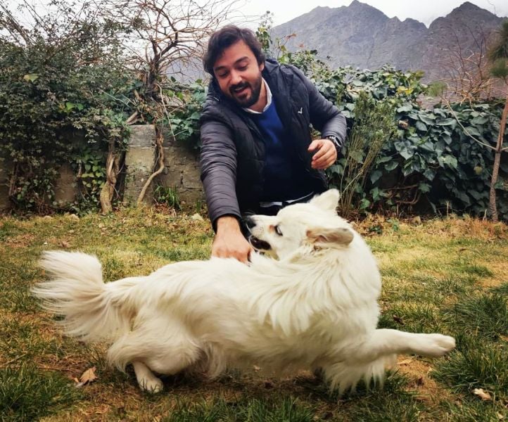 Asfar Hussain playing with his pet dog Roussie