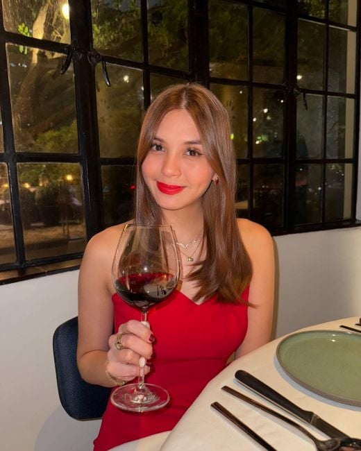 Ashley Ortega with a glass of alcohol