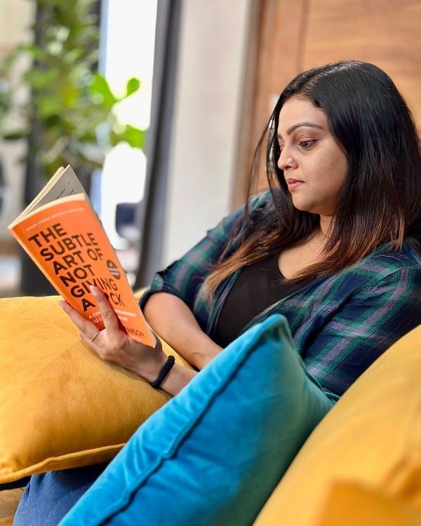 Aswathy Sreekanth reading the book Subtle Art of Not Giving a Fuck by Mark Manson