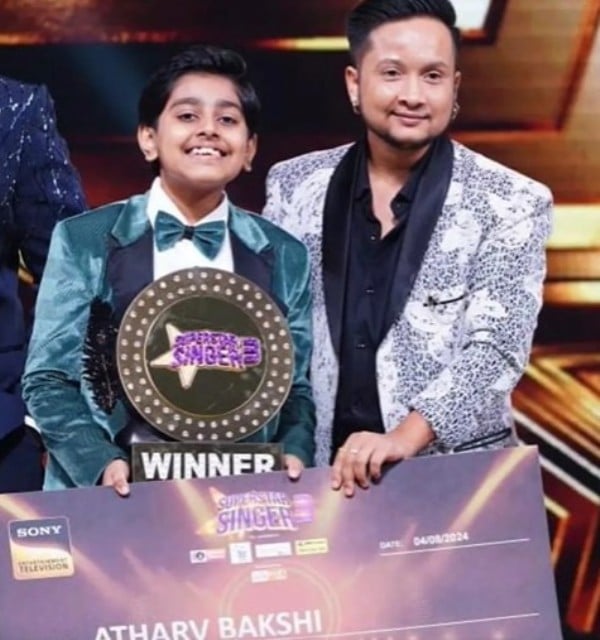 Atharva Bakshi posing with his team captain and trophy after winning the reality show