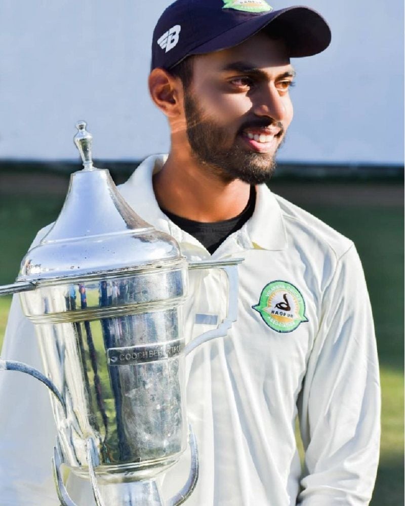 Atharva Taide holding the Under-19 Coochbehar Trophy