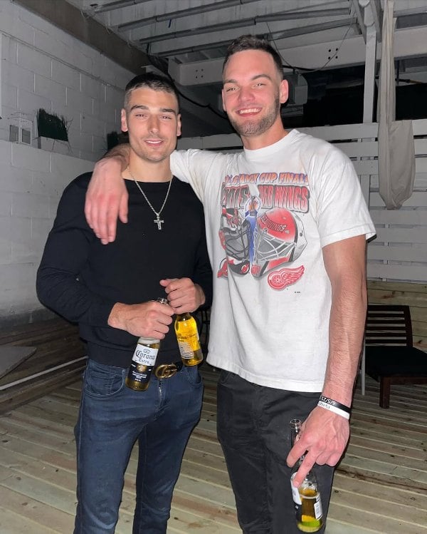 Austin Shepard (left), while holding two botttles of beer