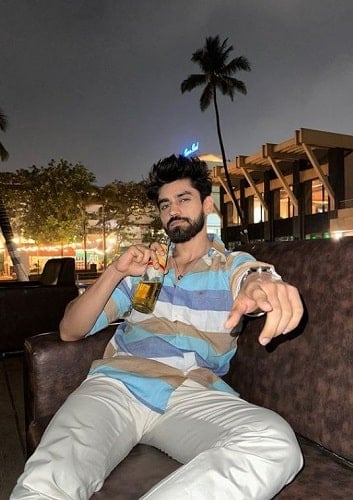 Avinash Mishra holding a bottle of beer
