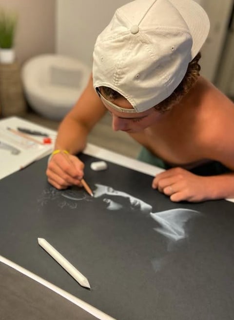 Benson Boone while sketching the cover of the song Ghost Town