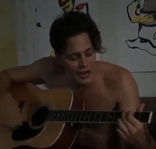 Bill Skarsgård playing a guitar
