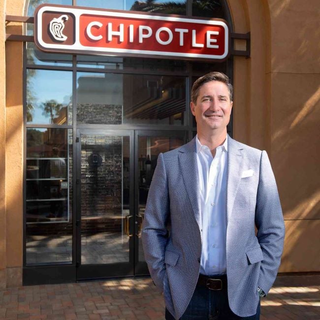 Brian Niccol standing in front of Chipotle restaurant