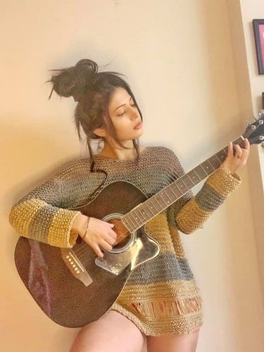 Charlie Chauhan playing a guitar