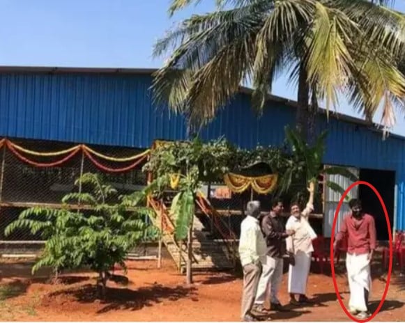 Chikkanna posing outside his goat and sheep farming business in Mysore