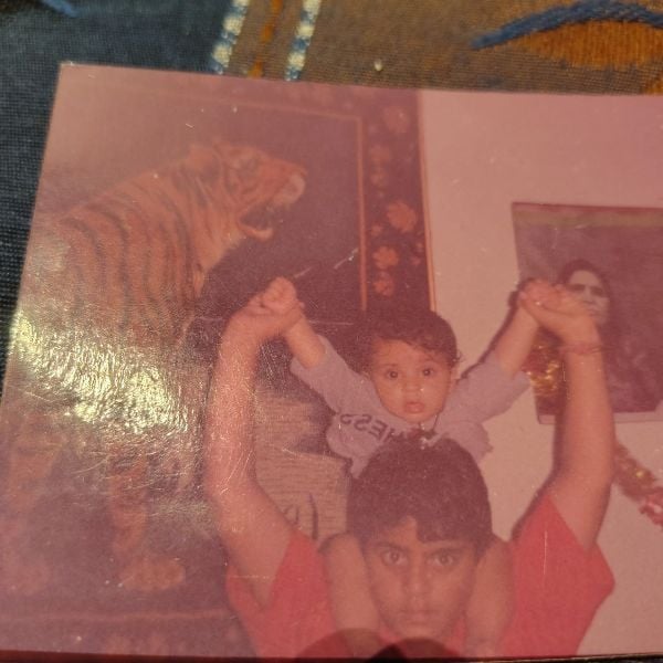 Childhood photo of Vivrant Sharma while sitting on the shoulders of his elder brother