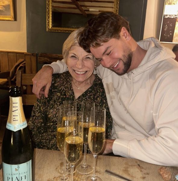Christopher Hughes drinking champagne with his mother