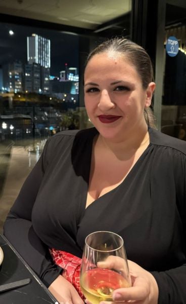 Claire Apap drinking champagne at a restaurant in Malta